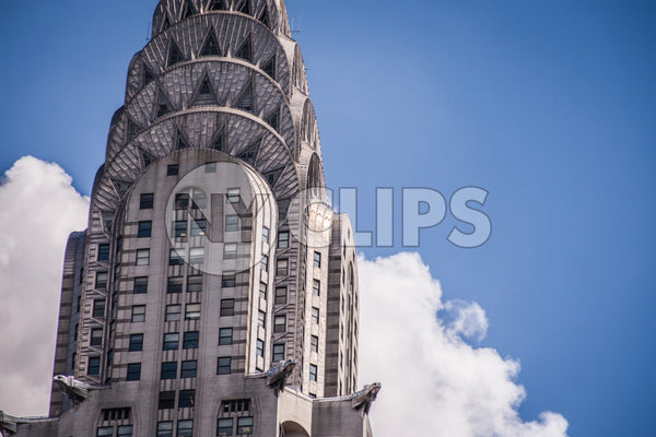 tight shot of top of Chrysler Building famous Art Deco style skyscraper with blue sky on summer day in Manhattan NYC