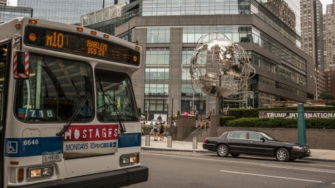 bus stop at Columbus Circle with famous globe sculpture and people in Midtown Manhattan on sunny summer day in NYC