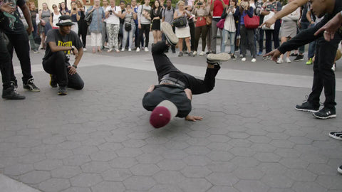 B-boy breakdancing in Washington Square Park on summer day - windmills and spinning in NYC