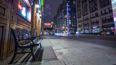 nightlife street bench outside pub in Manhattan - 4K time-lapse with streaks of light from cars