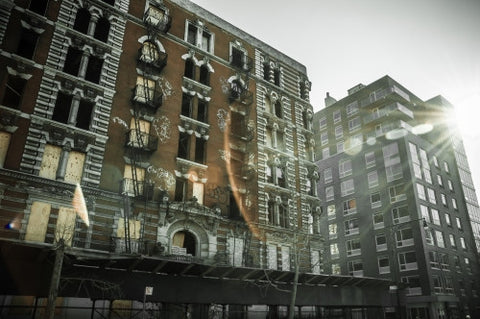 gritty tenement building with graffiti and fire escapes in Harlem, Uptown Manhattan architecture in poor neighborhood