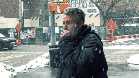 man smoking cigarette in snow storm blizzard - snowing in New York City cold winter NYC