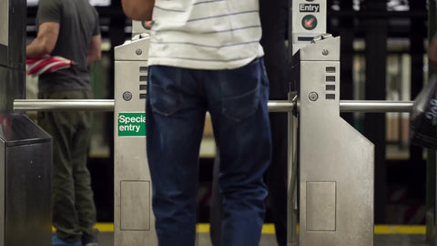 man entering turnstile with special entry in subway station in summer NYC