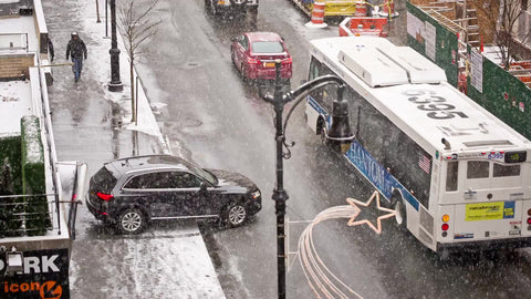car exiting parking garage into street - snowing in winter - cars driving in NYC