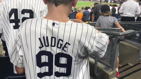 kid wearing Aaron Judge 99 jersey eating candy with father in Yankee Stadium Bronx New York City NYC 4K and 1080 HD