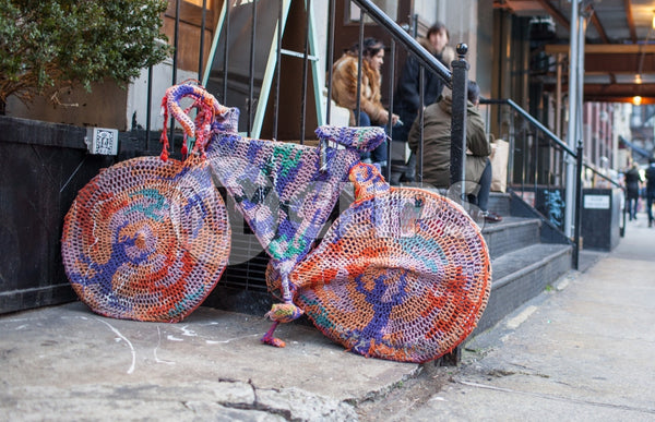 hipsters sitting on stoop with bicycle sweater parked on Lower East Side of Manhattan on fall day in NYC