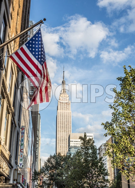 American flag and Empire State Building on beautiful colorful sunny summer blue sky day in Manhattan NYC