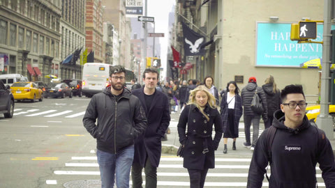 white man with glasses crossing street at Houston St crosswalk on winter day Manhattan NYC
