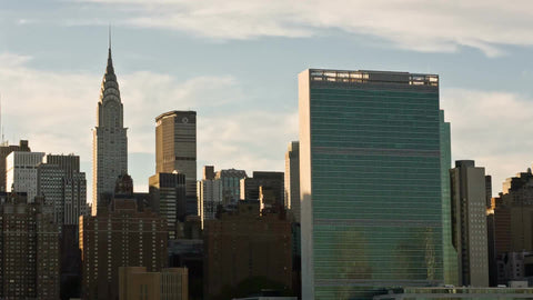 panning across Manhattan skyline at sunset with Empire State and Chrysler Building and United Nations