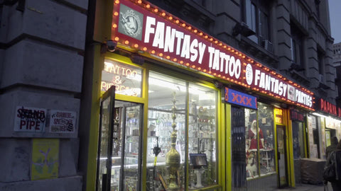 famous Fantasy Tattoo Party store sign with flashing lights on 6th ave in Greenwich Village in early evening
