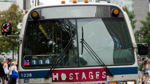 bus leaving at Columbus Circle on sunny day in summer with people crossing street at crosswalk