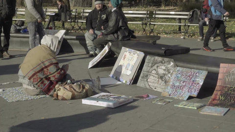 homeless artist selling art in Washington Square Park - bundled up on cold winter day