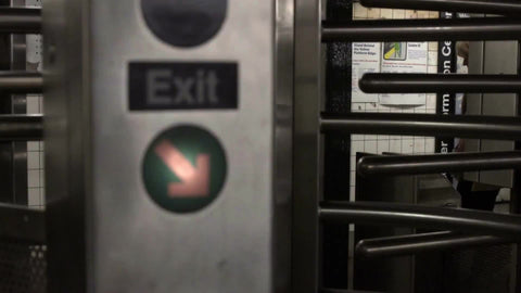 people exiting subway station revolving turnstile in slow motion