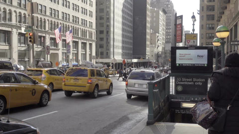 woman enters 6 train subway station entrance on Park Ave with Taxis at stop light in 1080 HD in NYC