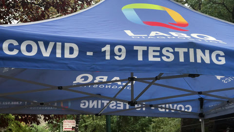 woman getting q-tip up nose for Covid test on street New York City