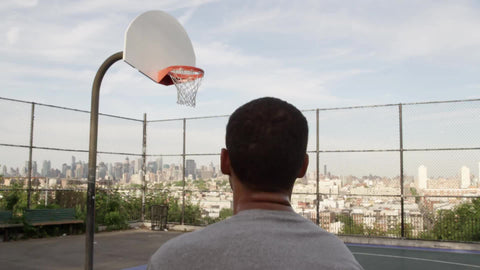 kid taking jump shot and scoring - basketball court overlooking Manhattan skyline