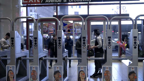 people looking for money and metro cards to enter Times Square turnstiles at night