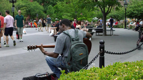 musician playing guitar in Washington Square Park on summer day in Manhattan NYC