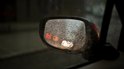 driver's side mirror with raindrops on rainy day - raining in NYC