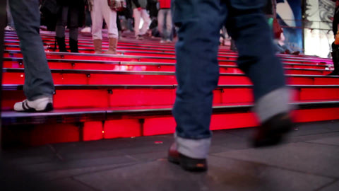Times Square red steps with close-up of feet walking up stairs