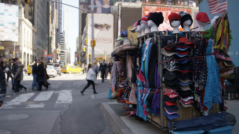 hats being sold by street vendor in Times Square during day - 4K slow motion in NYC