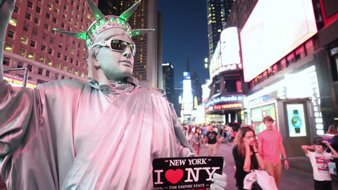 Times Square at night with performer dressed in Statue of Liberty costume