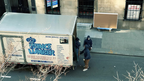 movers unloading lumber from truck on street in NYC