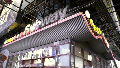 exterior subway station lights off Times Square at night on corner