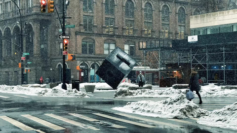 woman in mask crossing snowy street Cooper Square cube sculpture snowing winter Manhattan New York City NYC