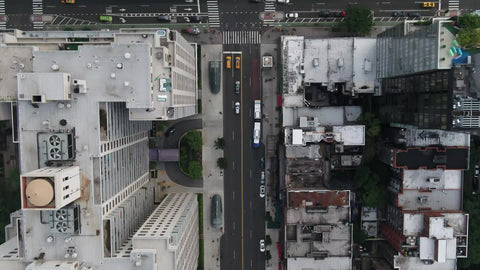 slow overhead aerial of buildings and cars driving in Midtown Manhattan traffic NYC