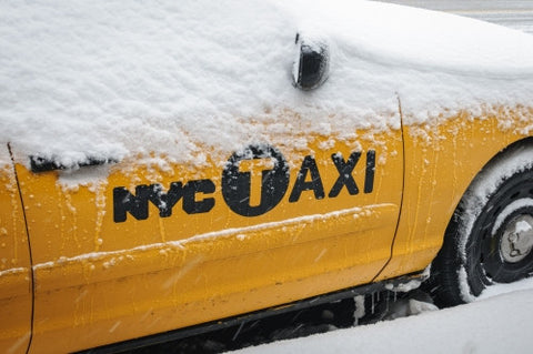 taxicab covered in snow - snowing in winter blizzard