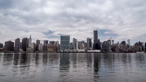 pushing in on Manhattan skyline with ripples in water - East River reflection of landmark skyscrapers in 4K New York City