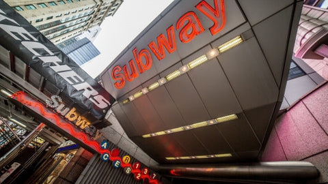 Times Square subway sign on 8th Ave in Manhattan - bright lights overwhelming train station