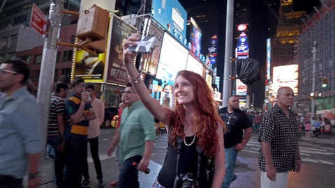 girl recording selfie with smartphone in Times Square on summer night