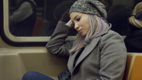 woman looking down and out subway window from moving train - thinking - 4K NYC