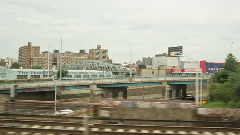 crossing Bronx River into Harlem with housing projects from moving subway train in NYC