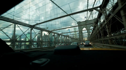 driving across Brooklyn Bridge - view of Manhattan skyline in rear window view in NYC