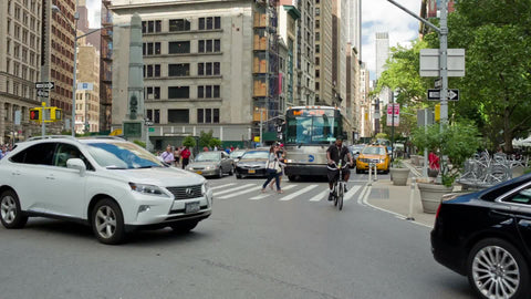 cars and taxis driving on Broadway and 5th Ave - tilting up to Empire State Building in Manhattan