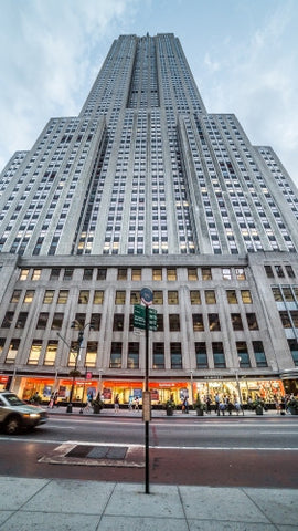 towering street view of Empire State Building in early evening with bus stop on 34th St in Manhattan