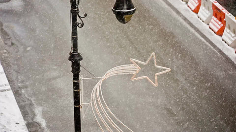 double decker tour bus driving down street in snow storm - snowing in winter blizzard from high view