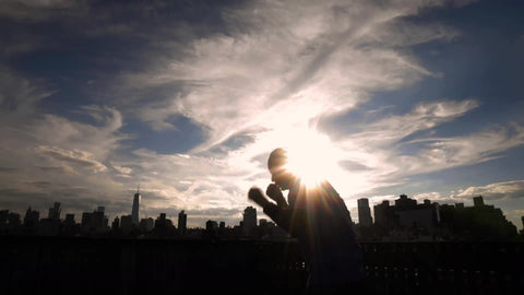 silhouette of man boxing on New York City rooftop with Manhattan skyline at sunset