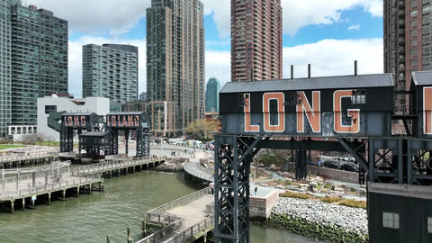 Long Island sign with city buildings on water in New York