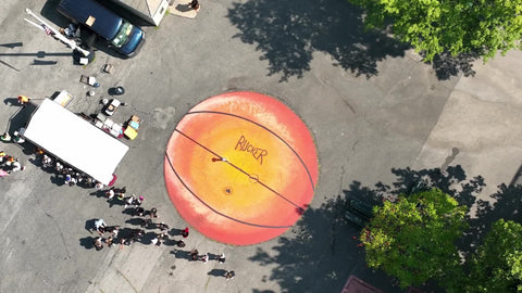 zooming out from Rucker basketball image on ground at park in Harlem New York City