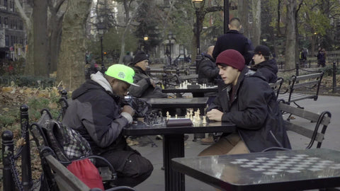 people at chess tables in autumn Washington Square Park cold fall in New York City