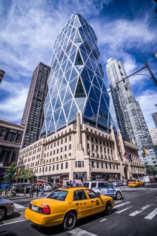 taxicab driving in traffic past Hearst Building in Midtown Manhattan