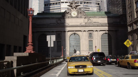 taxi cab driving from Grand Central Station Terminal exterior with clock on Park Ave Midtown Manhattan NYC