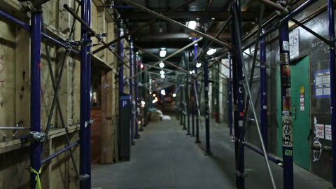 empty street with scaffolding at night - boarded up - nighttime
