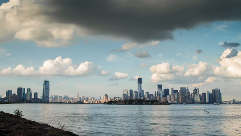Freedom Tower in Manhattan skyline from day to sunset to night - 4K timelapse from Brooklyn across East River water