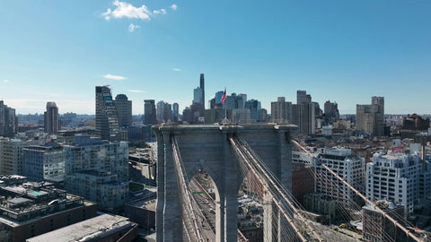 aerial circling Brooklyn Bridge American flag New York City landmarks