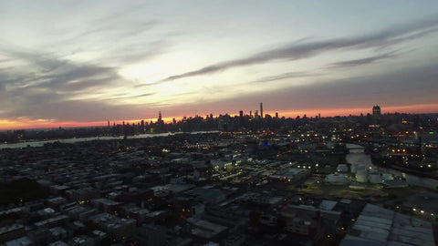 aerial over the Bronx with Manhattan skyline at sunset